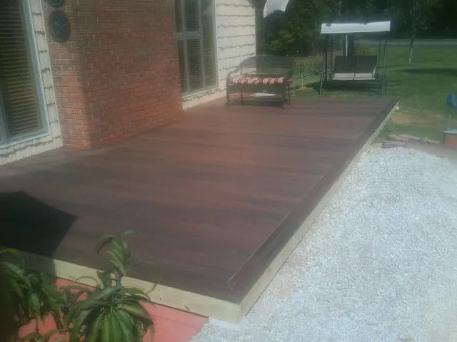Freshly stained wood deck built against a brick home in Smithville